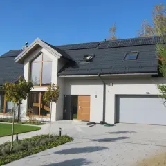 Nowoczesny dom z panelami słonecznymi. Zastanawiasz się, ile kosztuje budowa domu 100m2? Ten dom może być inspiracją.