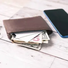 Portfel z pieniędzmi i kartami, klucze i telefon. Może to być symbol zarządzania finansami, w tym rozważania o funduszach wsparcia kredytobiorców.
