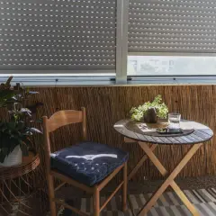 Przytulna loggia z krzesłem, stolikiem i roślinami. Idealne miejsce na poranną kawę na balkonie.