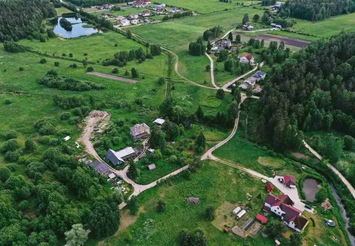 Wieś z domami i drogami, gdzie służebność gruntowa może dotyczyć dostępu do jeziora lub lasu.