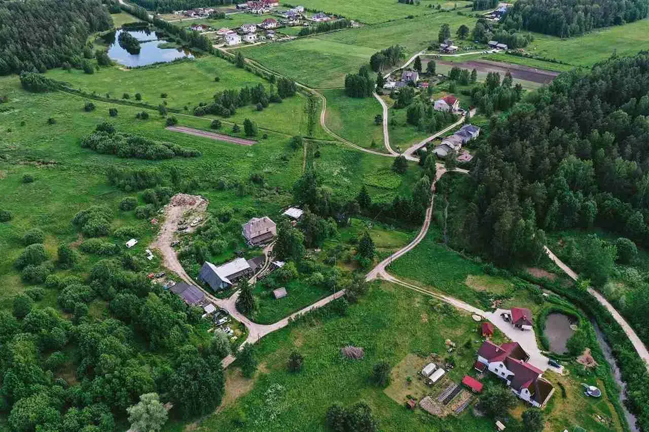 Wieś z domami i drogami, gdzie służebność gruntowa może dotyczyć dostępu do jeziora lub lasu.