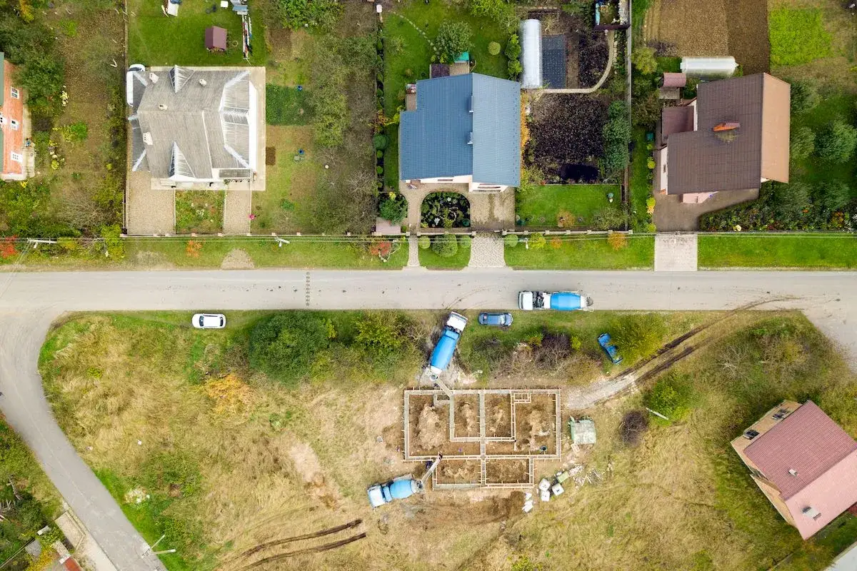 Budowa domu bliźniaka w toku. Betonowozów dostarczają materiał na fundamenty.
